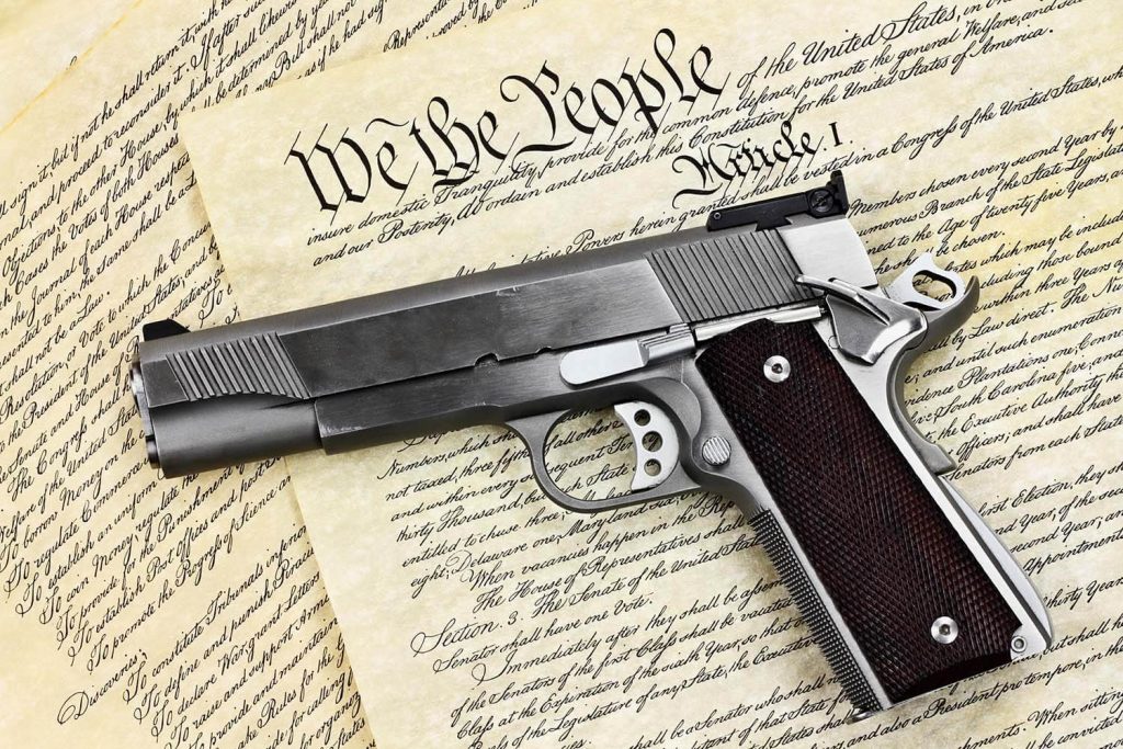 A Gun With American Constitution Article Behind