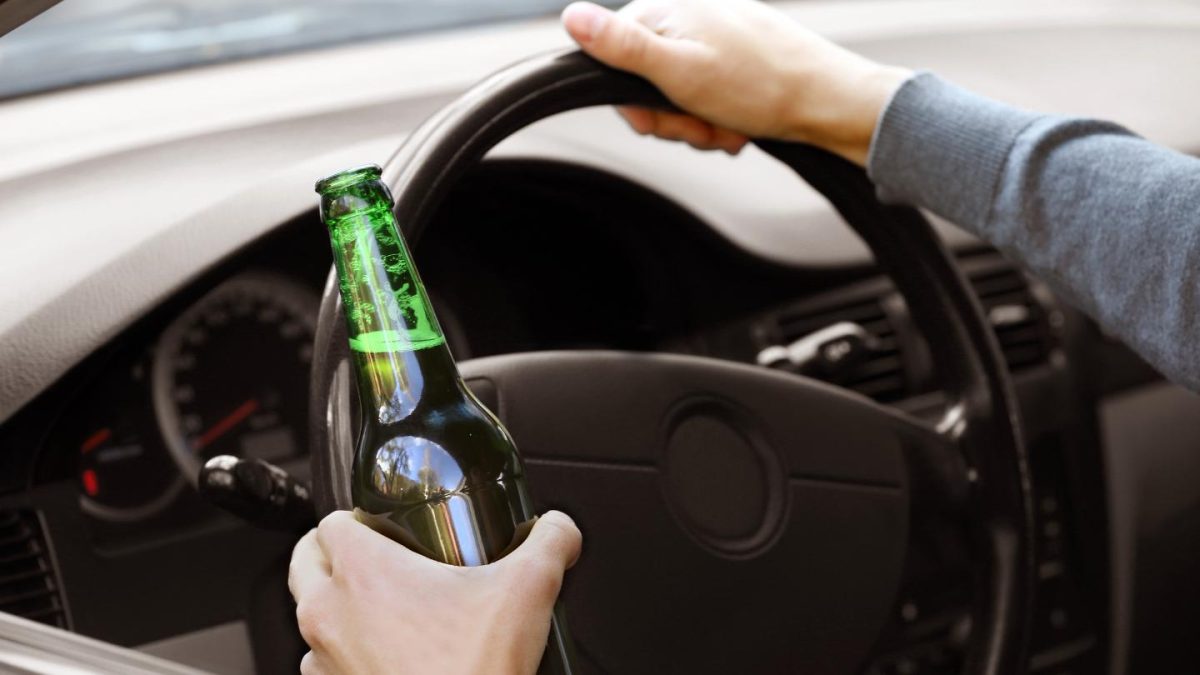 Driver Holding a Beer Bottle While Steering